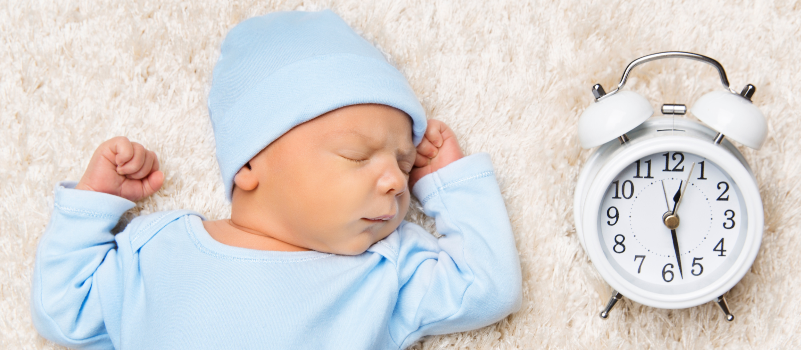 Baby sleeping next to clock for wake windows