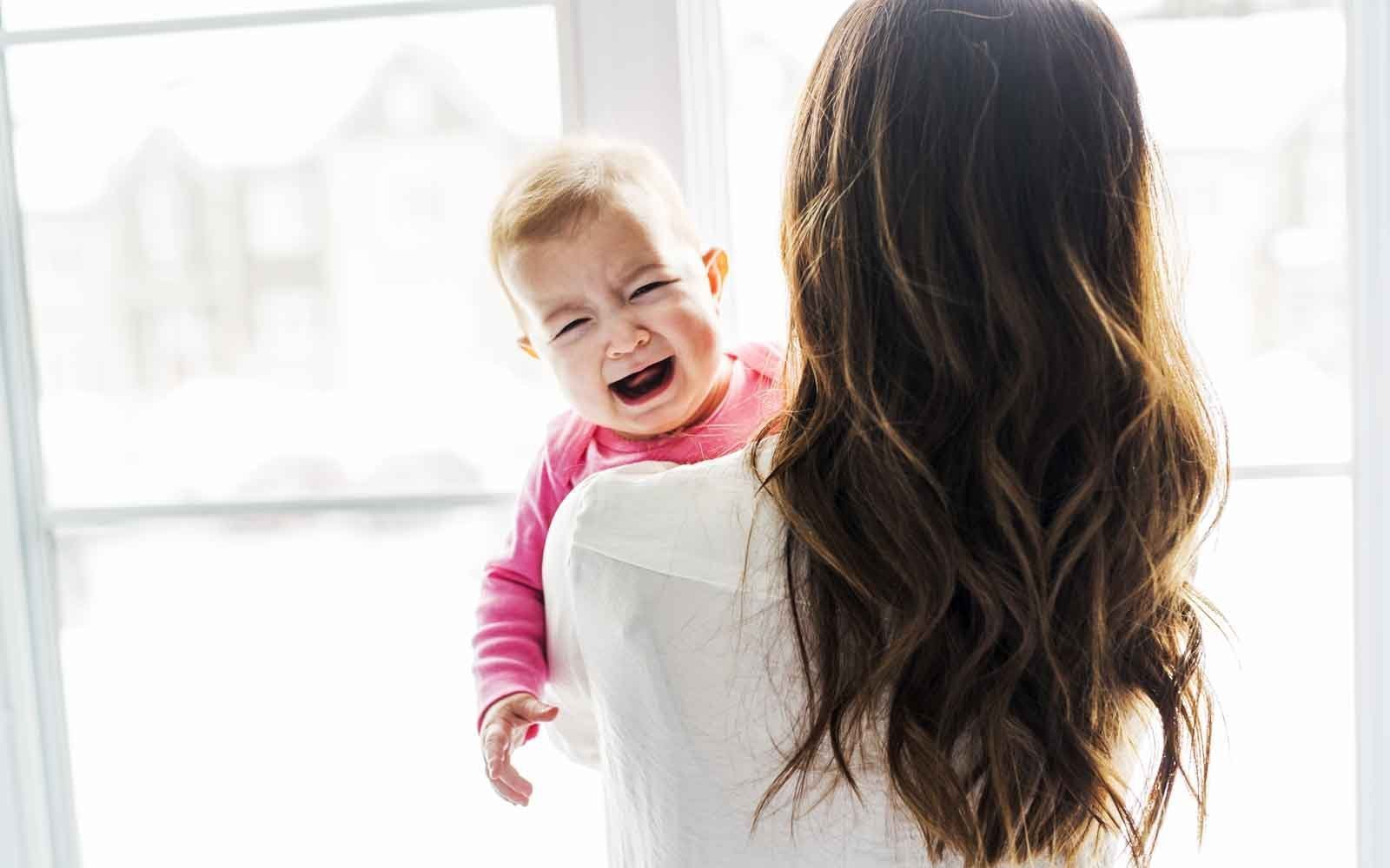 Picture of a mother and baby, the baby is crying and has high cortisol due to bad sleep training