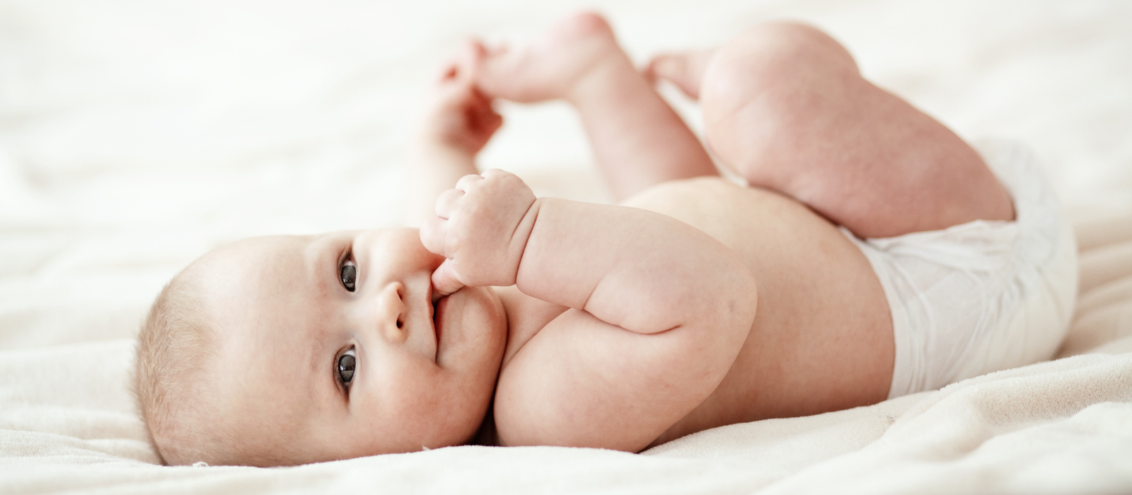6 month old baby lying on bed