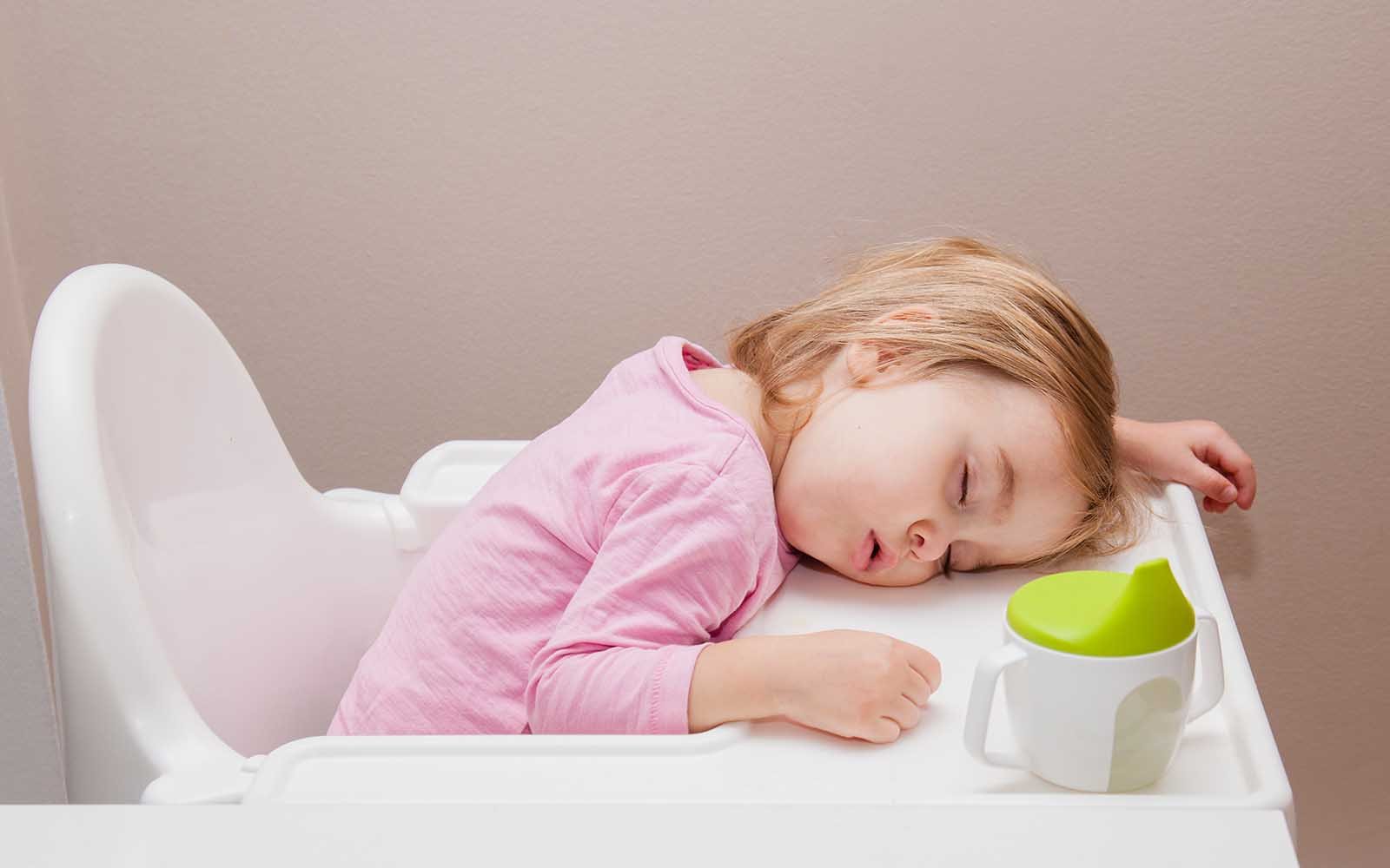 Toddler asleep on high chair due to the 12 - 14 month sleep regression