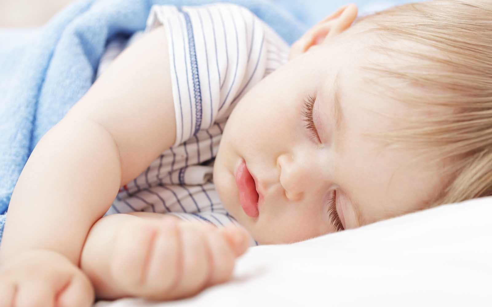 baby boy in blue sleeping through the night